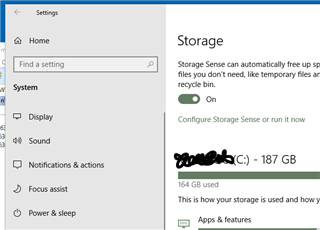 Windows Settings menu with System selected and Storage option open showing Storage Sense is turned on with 164 GB used of 187 GB.